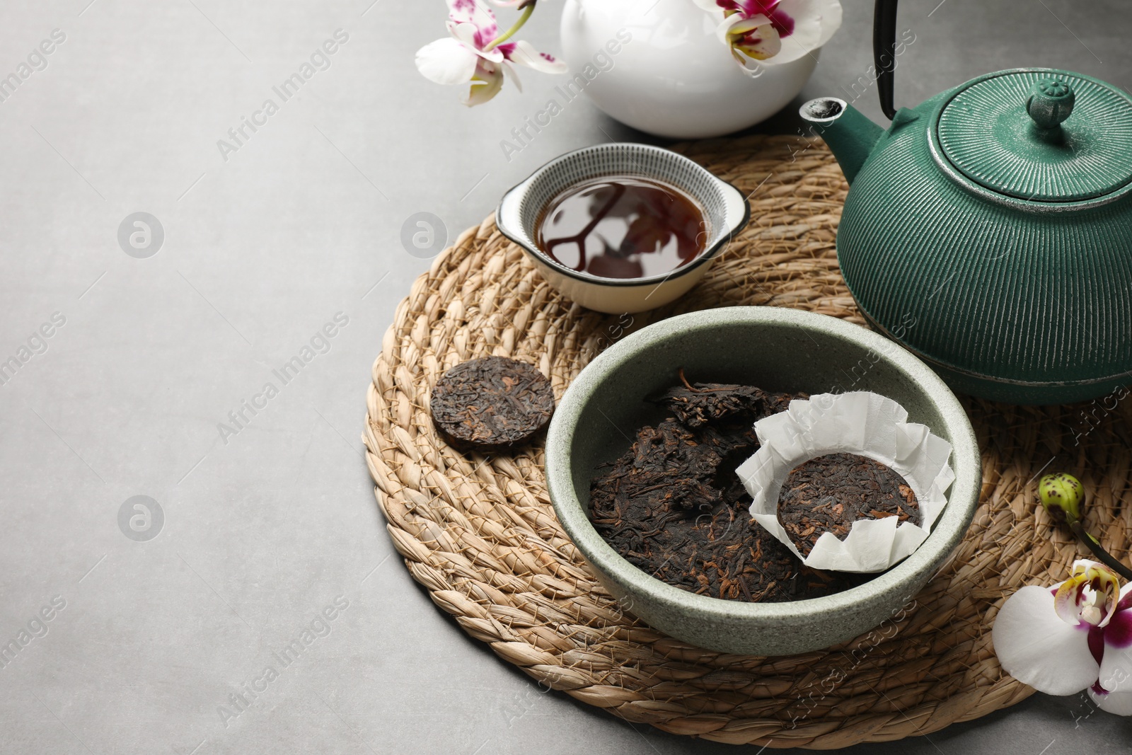 Photo of Composition with aromatic pu-erh tea on light grey table. Space for text