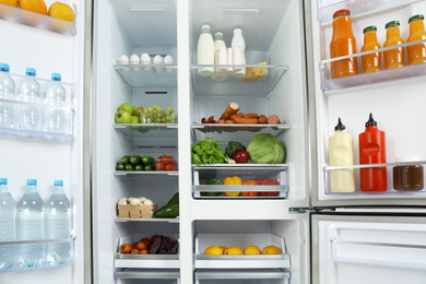 Open refrigerator full of different fresh products