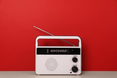 Photo of Retro radio receiver on table against red background