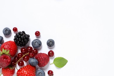 Many different fresh berries on white background, flat lay. Space for text