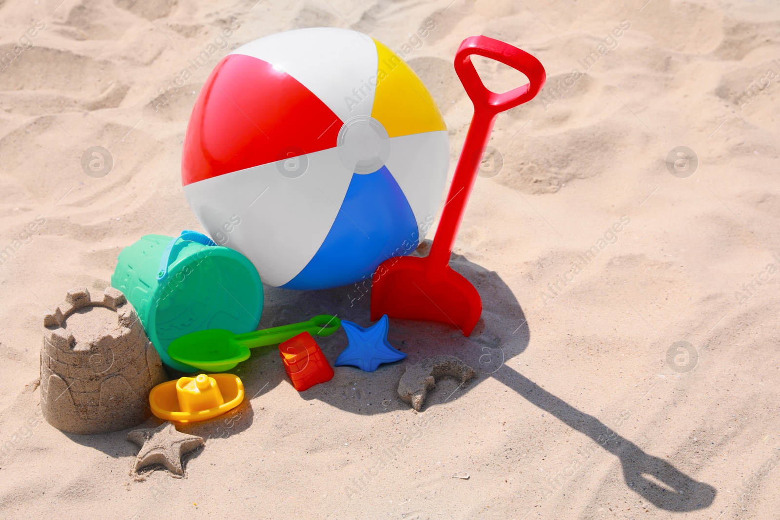 Photo of Different beach toys and inflatable ball on sand outdoors, space for text