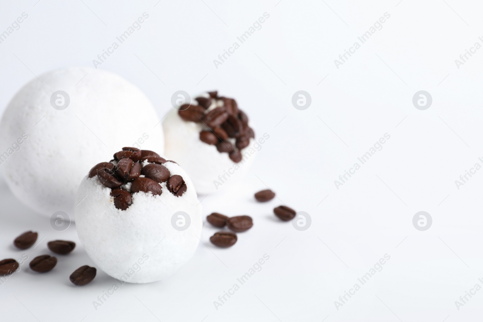 Photo of Bath bombs and coffee beans on white background, space for text