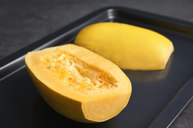 Baking tray with cut spaghetti squash on table