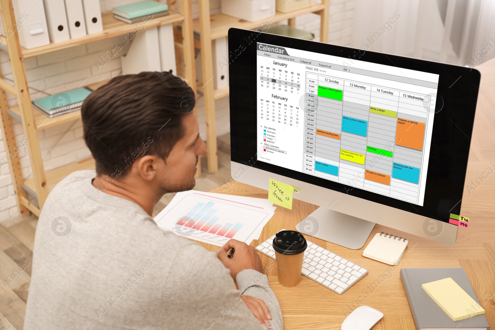 Photo of Handsome man using calendar app on computer in office