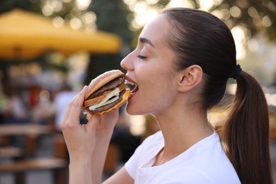 Photo of Lviv, Ukraine - September 26, 2023: Woman eating McDonald's burger outdoors