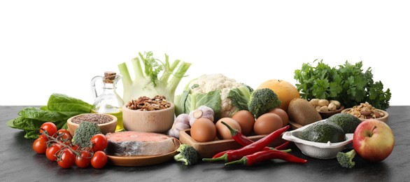 Many different healthy food on dark table against white background