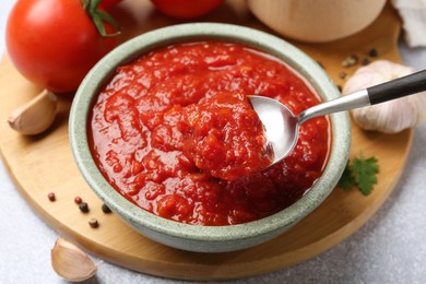 Photo of Eating homemade tomato sauce at light grey table, closeup
