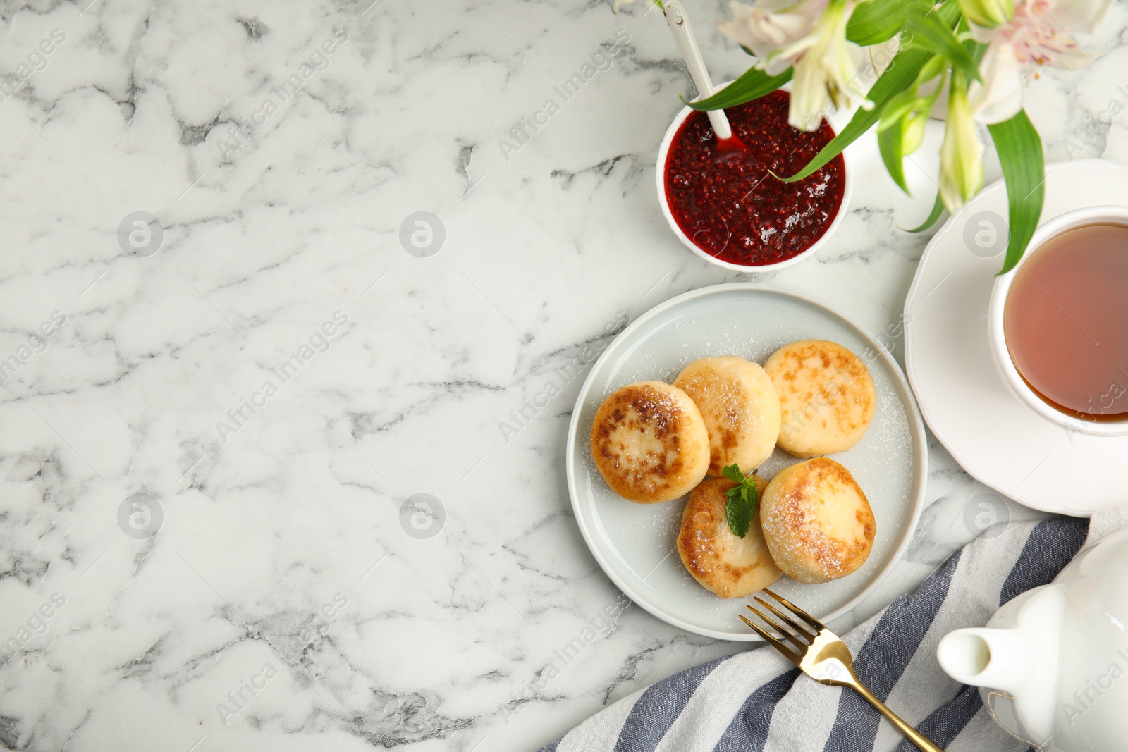 Photo of Delicious cottage cheese pancakes with icing sugar on white marble table, flat lay. Space for text