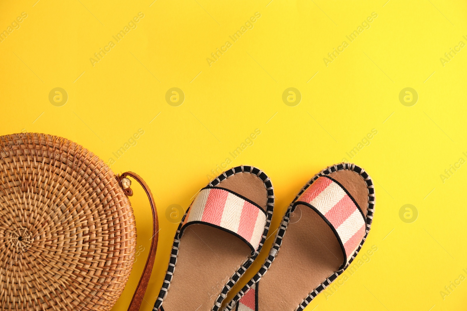 Photo of Flat lay composition with bamboo bag, sandals and space for text on color background