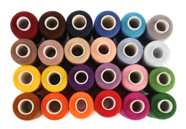 Photo of Set of colorful sewing threads on white background, top view