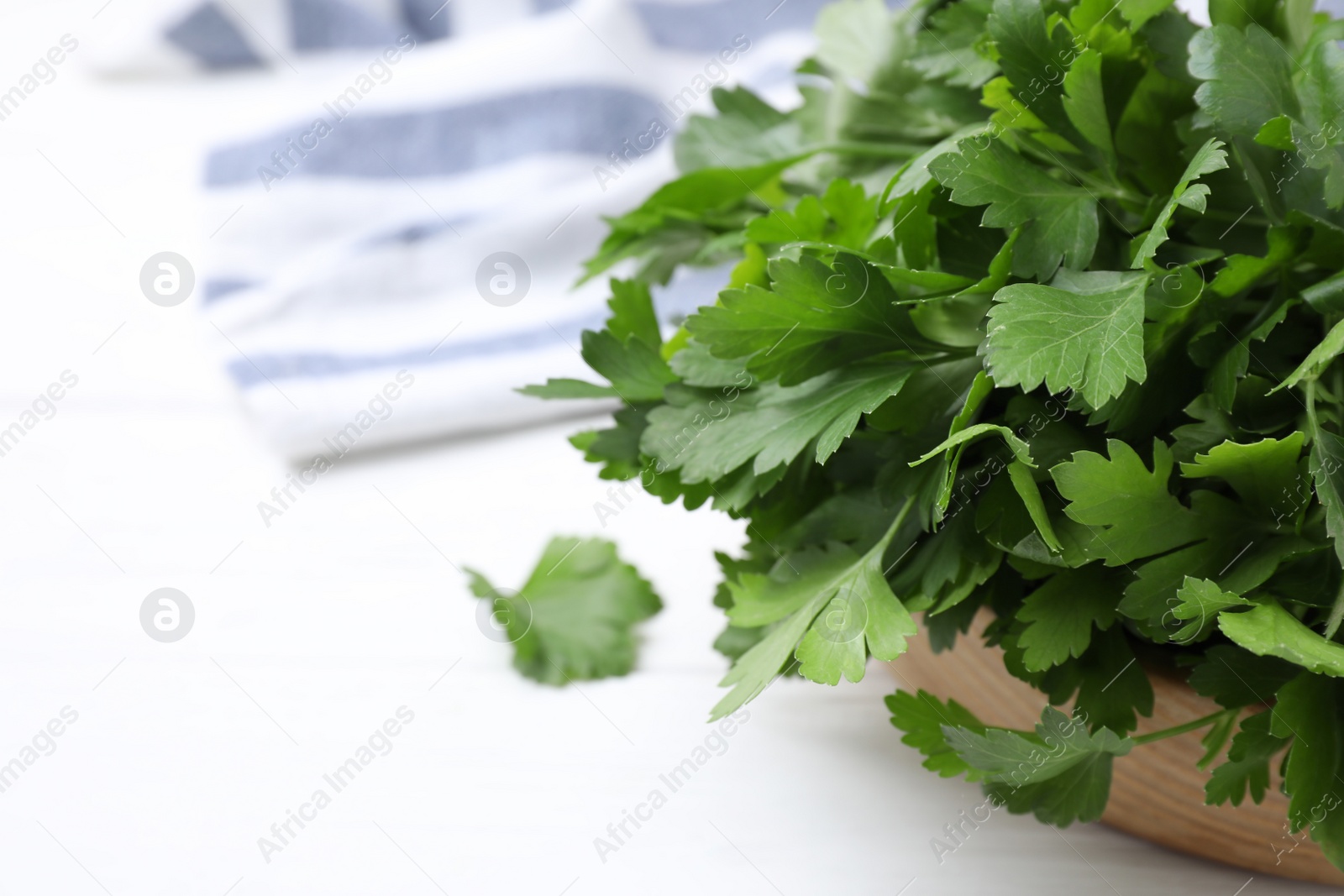 Photo of Bunch of fresh green parsley on white wooden table, closeup. Space for text