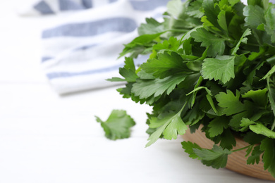 Bunch of fresh green parsley on white wooden table, closeup. Space for text