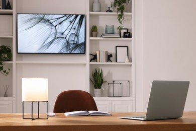 Photo of Cosy workplace near tv area with shelves. Interior design