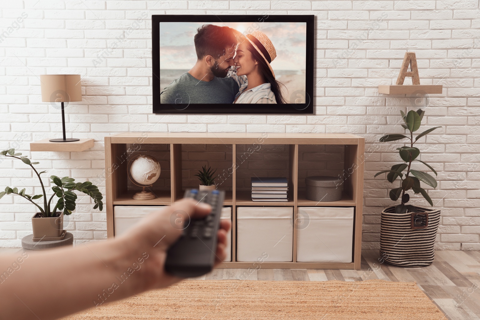 Image of Man watching romantic movie on TV at home