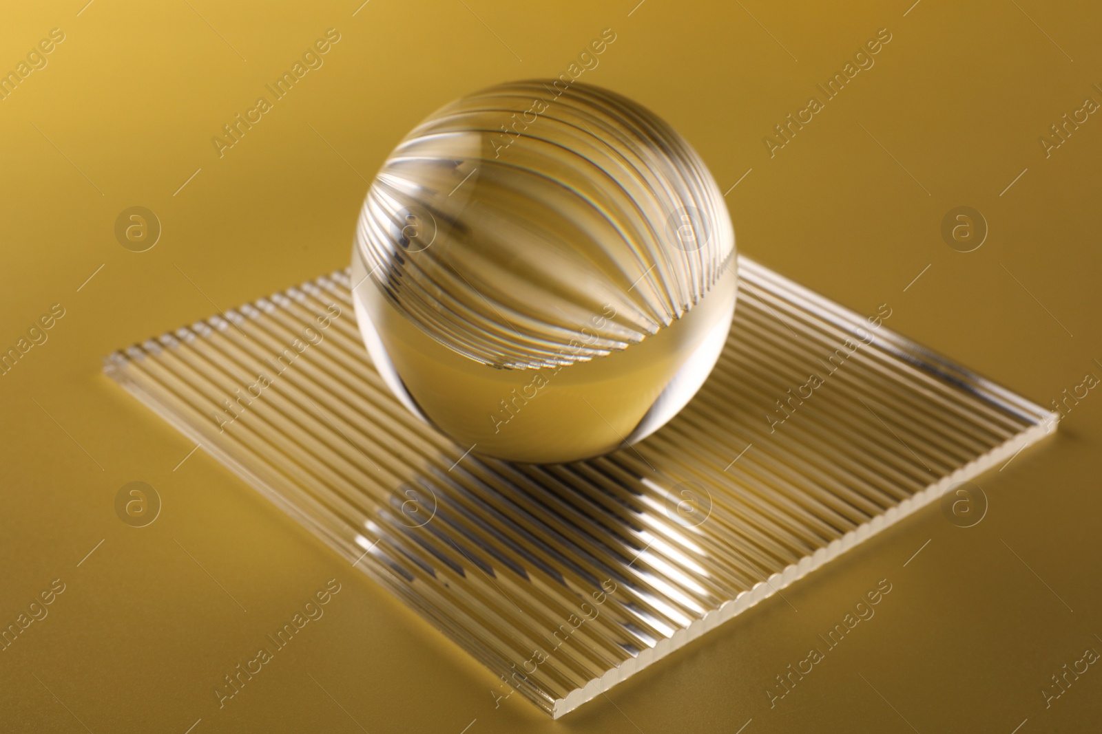 Photo of View of transparent glass ball on yellow background