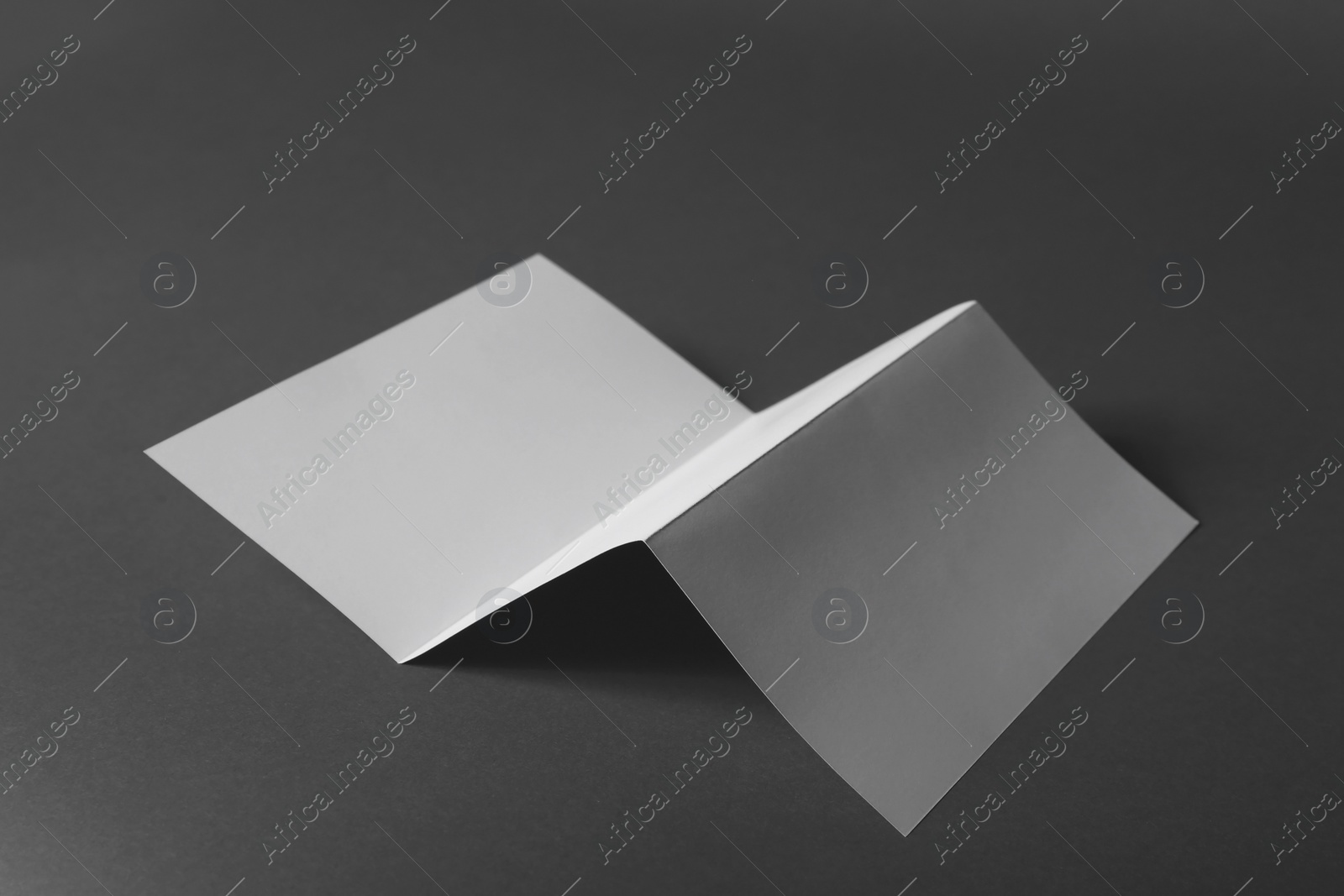 Photo of Blank brochure on dark grey background. Mock up for design