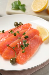 Photo of Delicious salmon carpaccio served on table, closeup