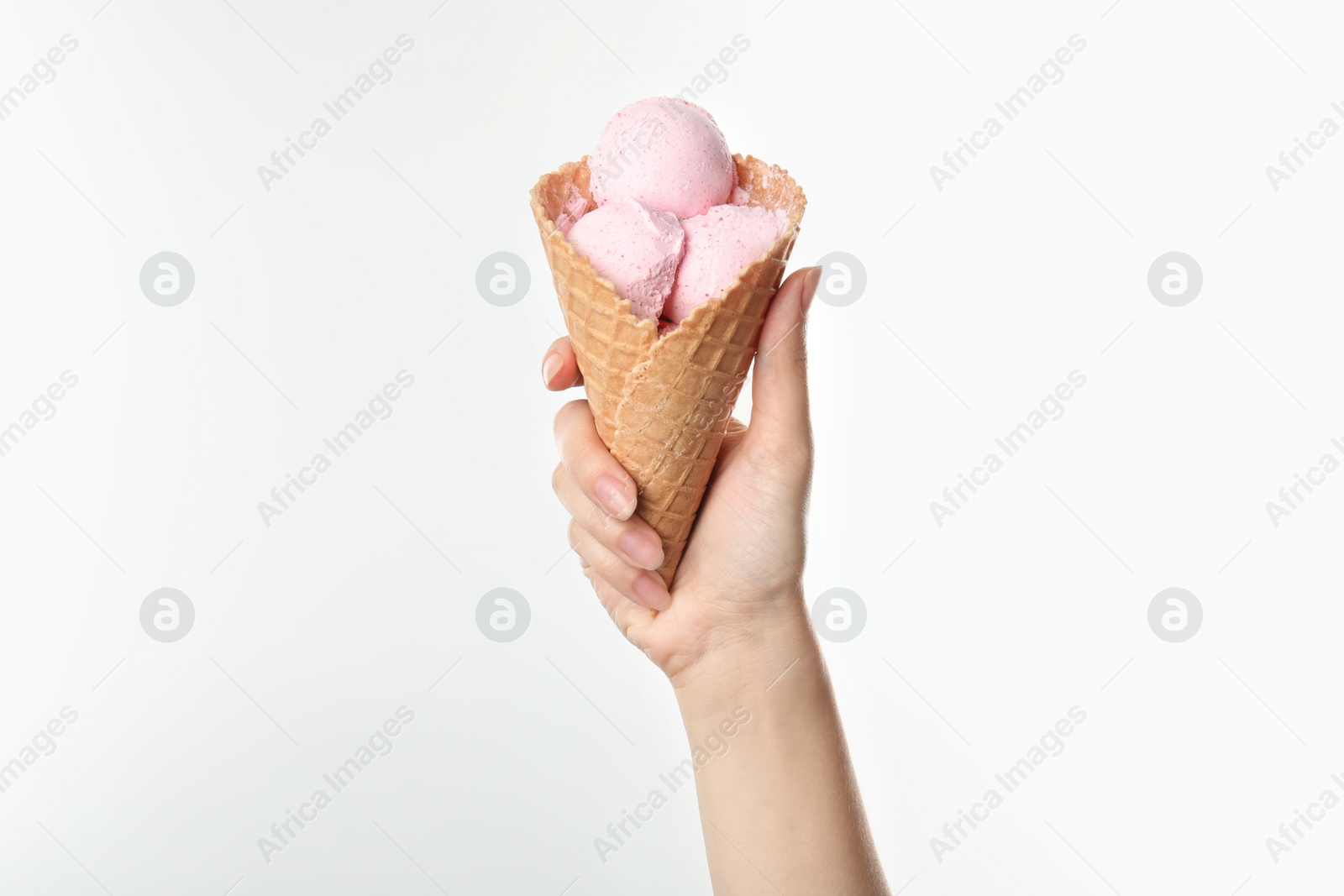 Photo of Woman holding delicious ice cream in waffle cone on white background, closeup