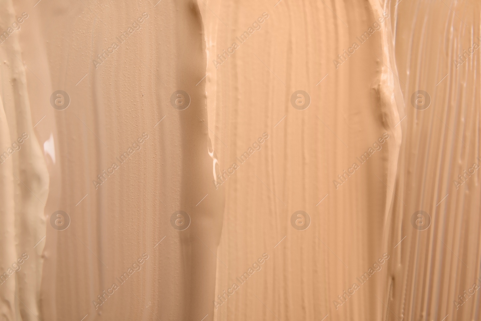 Photo of Samples of different foundation shades as background, top view