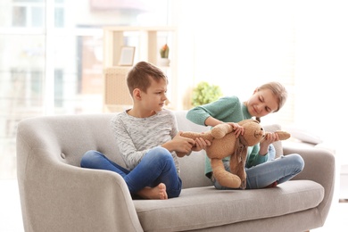 Brother arguing with sister on sofa at home