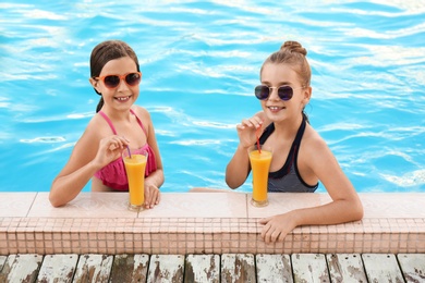 Happy girls with drinks in swimming pool