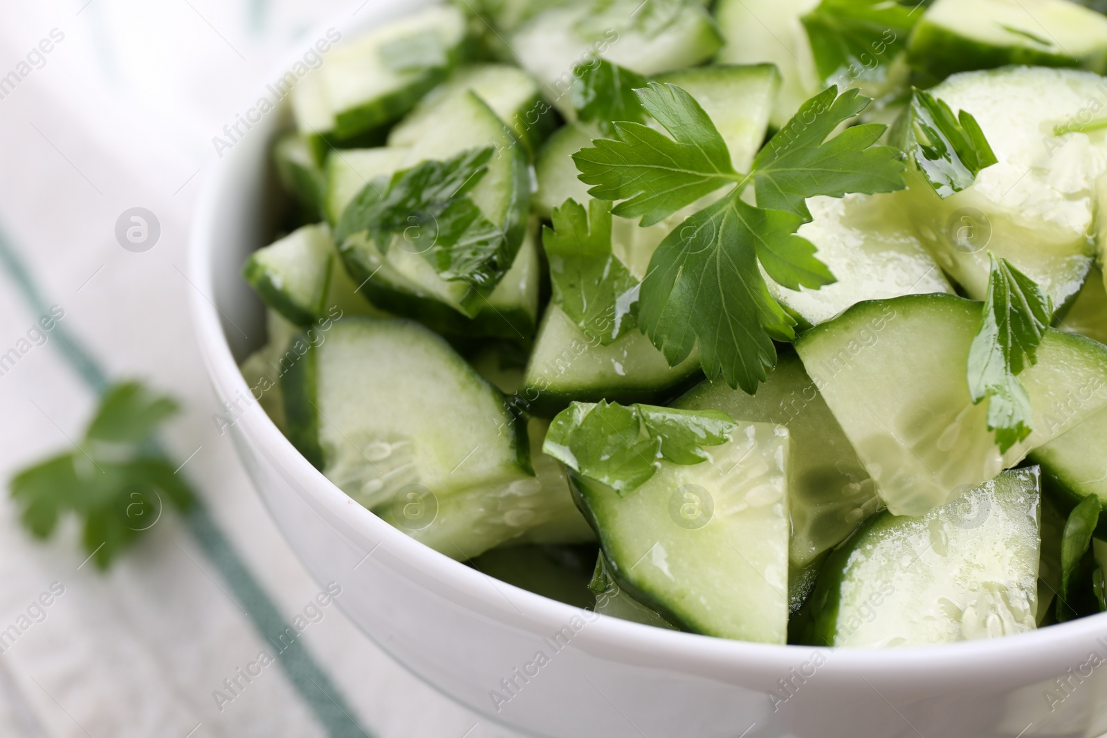 Photo of Delicious cucumber salad in bowl on table, closeup