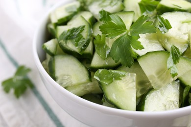 Delicious cucumber salad in bowl on table, closeup