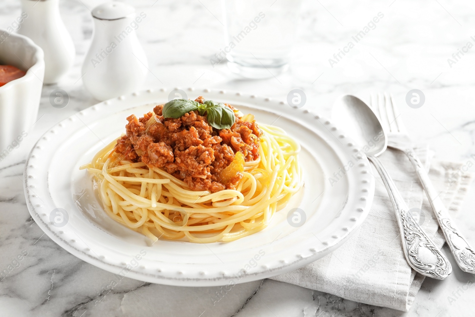 Photo of Plate with delicious pasta bolognese on table