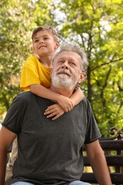 Photo of Senior man with his little grandson in park