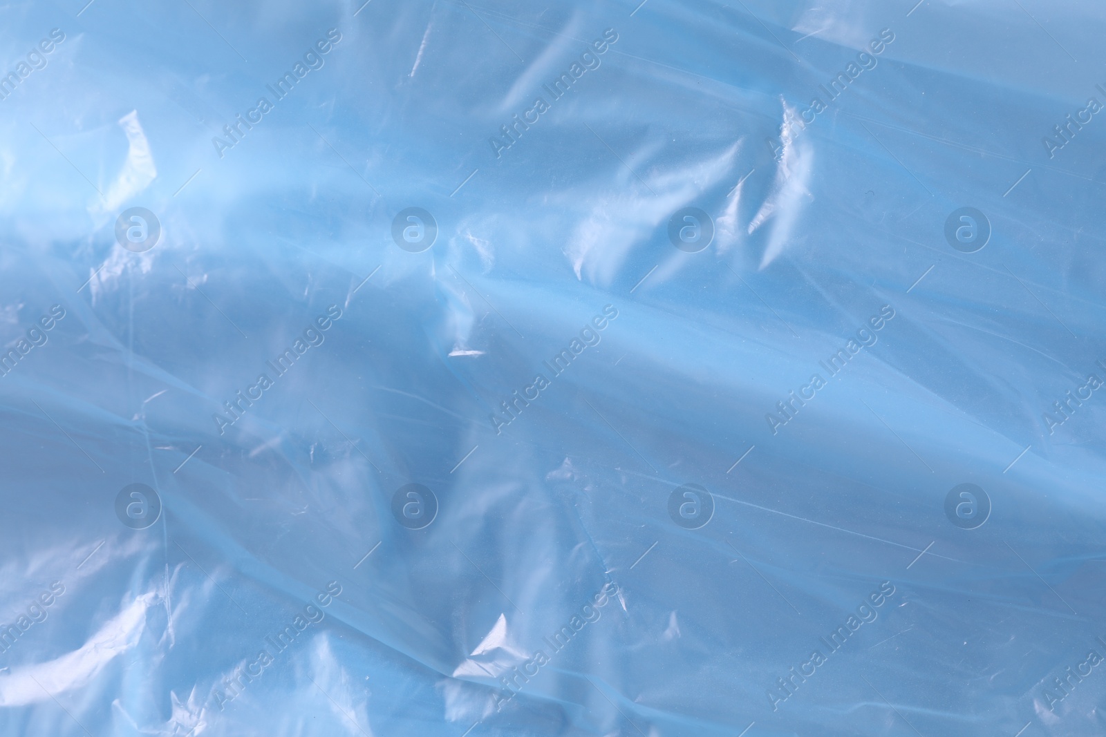 Photo of Texture of light blue plastic bag as background, closeup