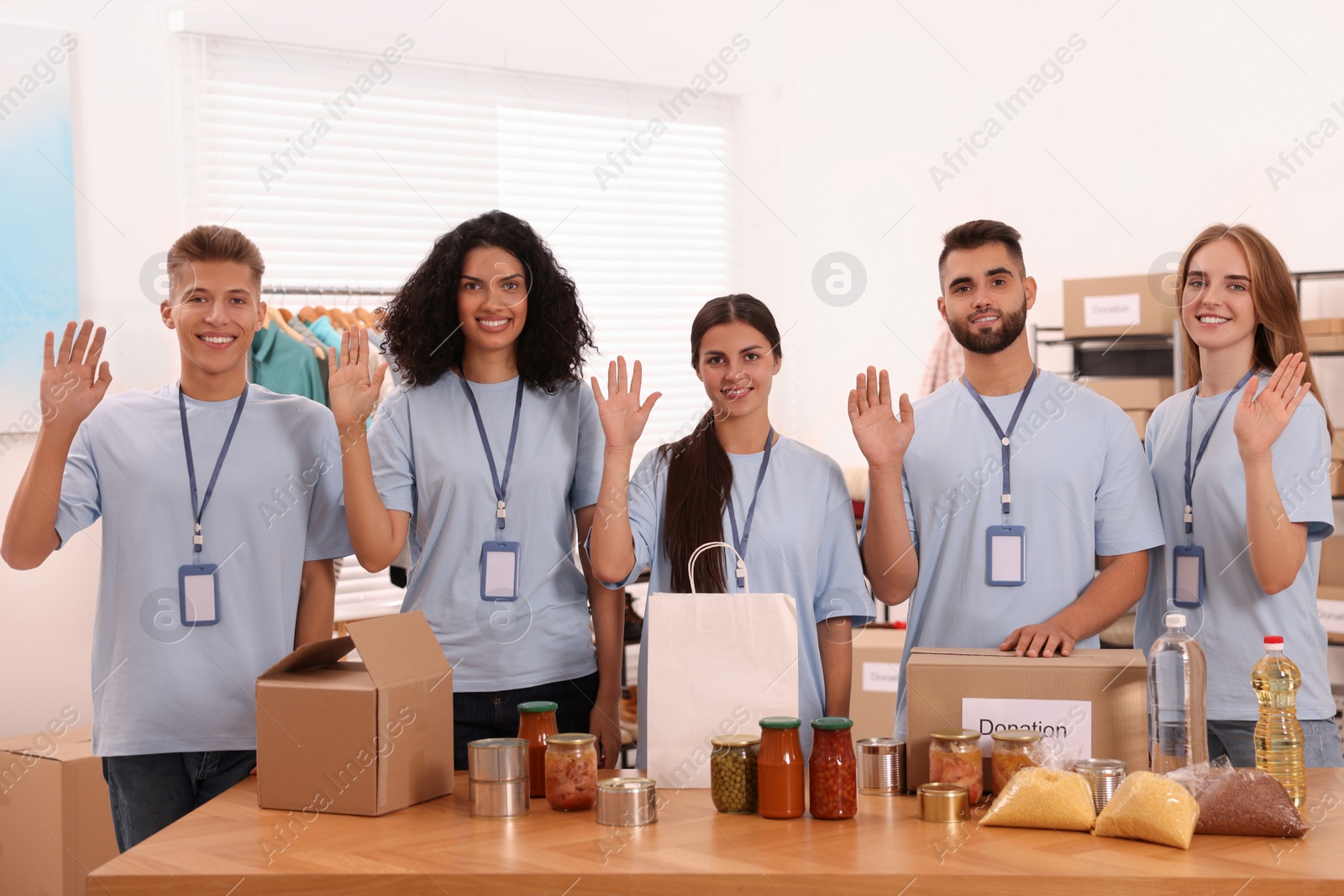 Photo of Portrait of volunteers and food products at table in warehouse