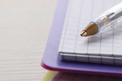 Photo of Ballpoint pen and notebook on wooden table, closeup. Space for text