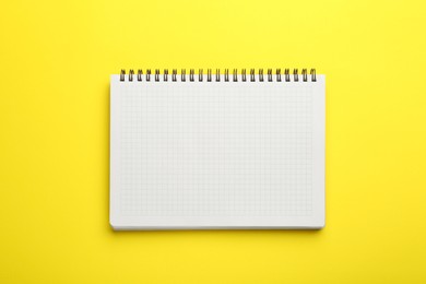 One notebook on yellow background, top view. Space for text