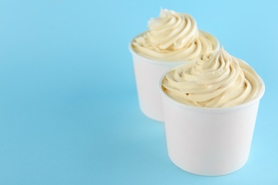 Cups with tasty frozen yogurt on blue background. Space for text