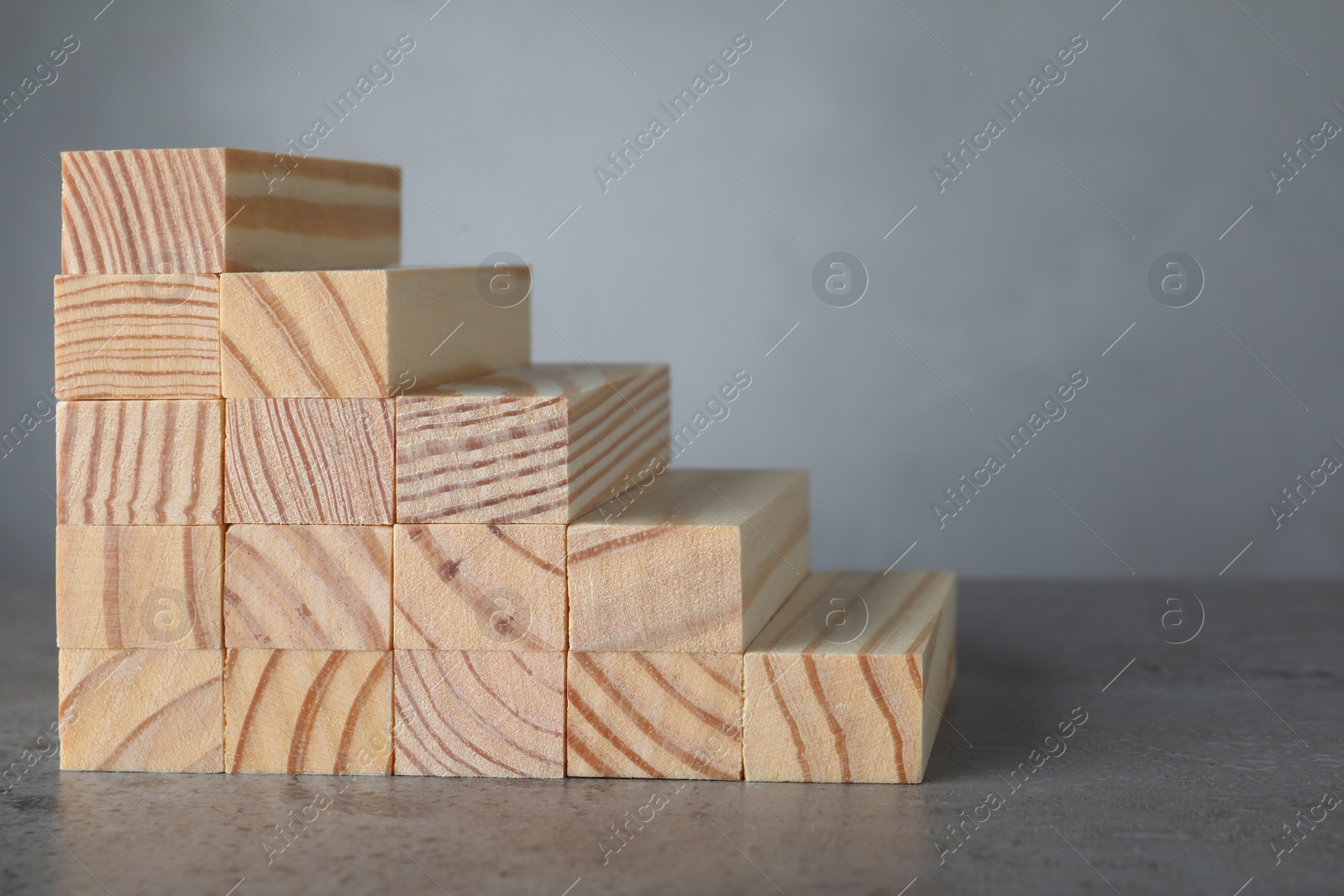 Photo of Steps made with wooden blocks on table against grey background, space for text. Career ladder