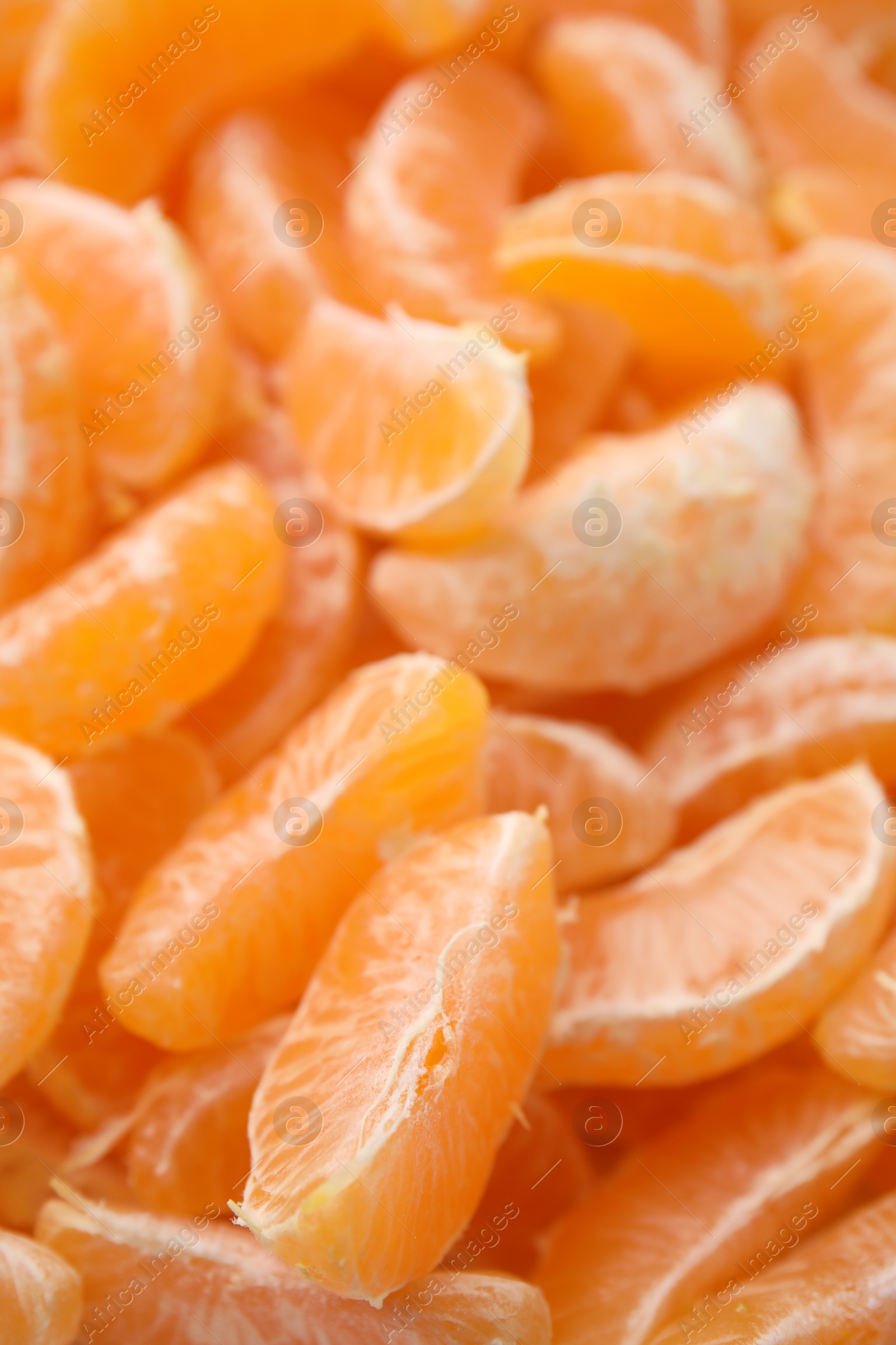 Photo of Segments of tasty tangerines as background, closeup