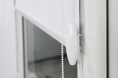 Photo of Window with white roller blind indoors, closeup