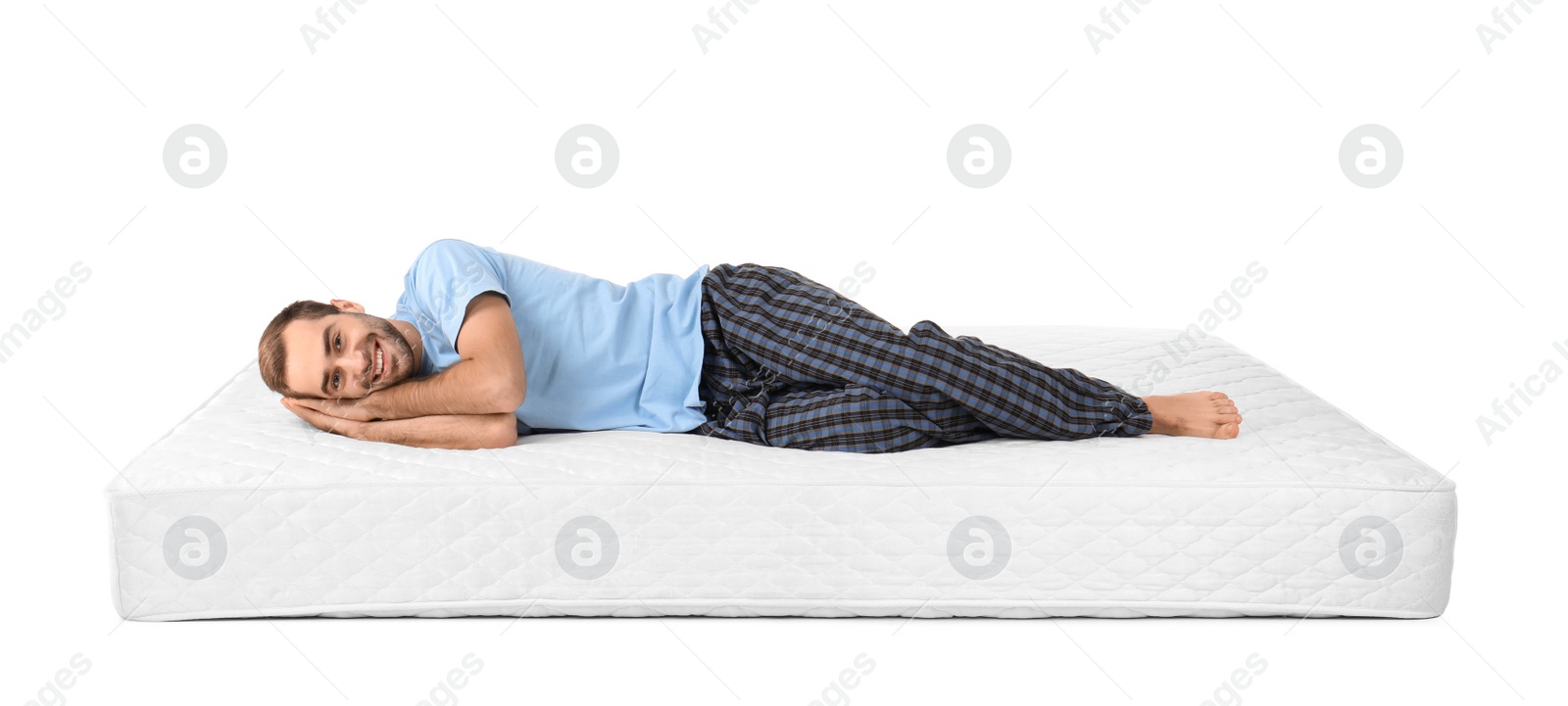 Photo of Young man lying on mattress against white background