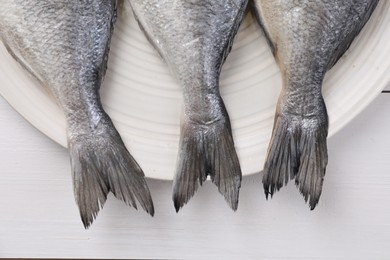 Fresh raw dorado fish on white wooden table, top view