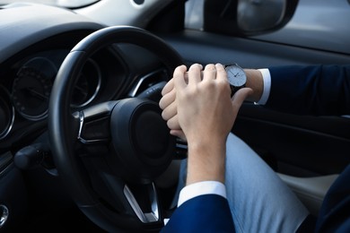 Photo of Man checking time in car, closeup. Being late