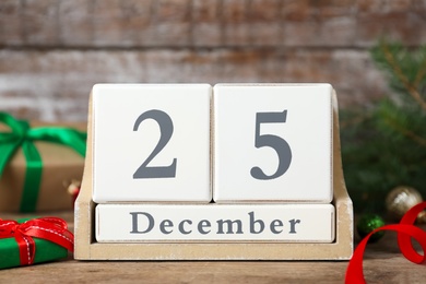 Wooden block calendar and Christmas decor on table. Holiday celebration