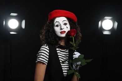 Photo of Young woman in mime costume with red rose performing on stage
