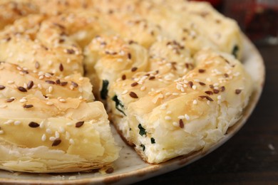 Photo of Delicious puff pastry with spinach on table, closeup