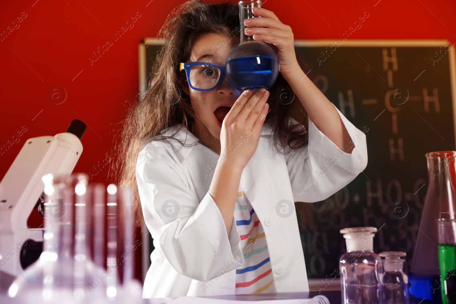 Photo of Child doing chemical research in laboratory. Dangerous experiment