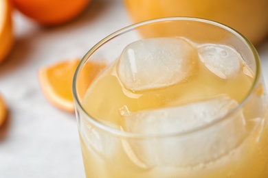 Photo of Glass of orange juice with ice cubes on table, closeup