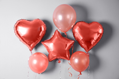 Photo of Different balloons near light wall. Festive decor