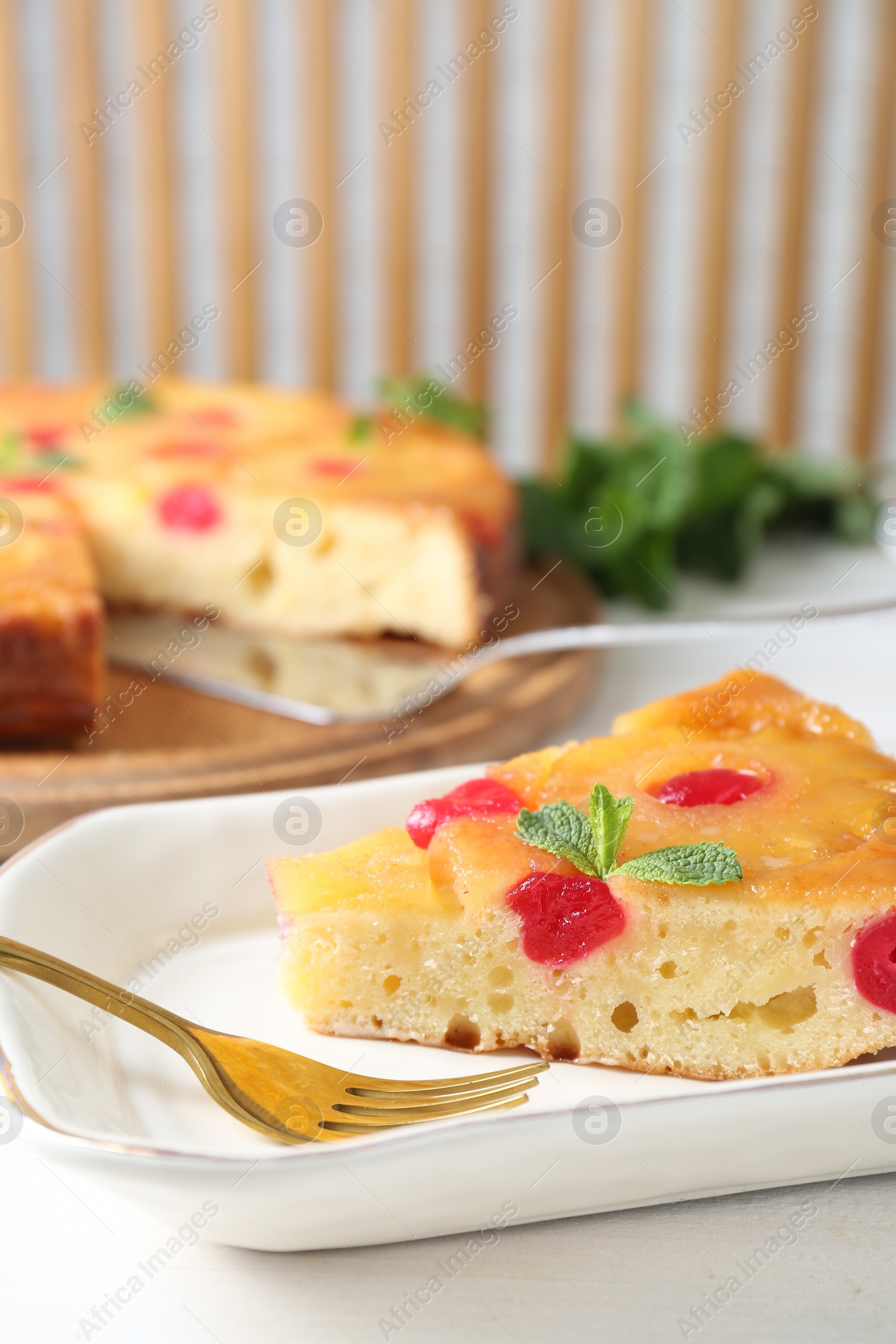 Photo of Piece of delicious pineapple pie with cherry and mint on white table