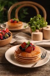 Photo of Tasty pancakes with fresh berries and mint on wooden table