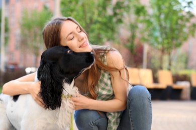 Photo of Young woman with her English Springer Spaniel dog outdoors
