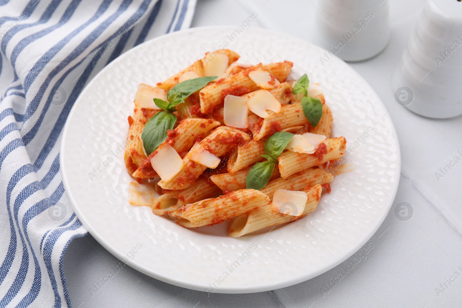 Photo of Tasty pasta with tomato sauce, cheese and basil on white table